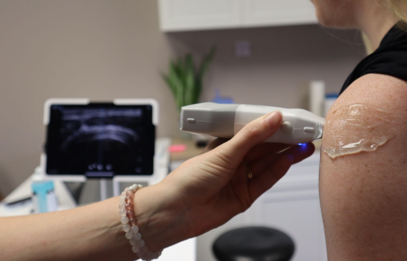 Medical professional performing ultrasound-guided musculoskeletal shoulder examination
